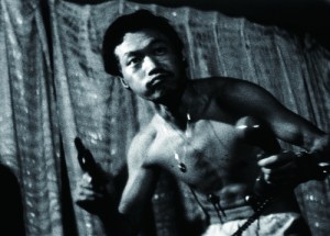 Yuichi Minato doesn't know if he's coming or going in the perplexing pink/yakuza film, Inflatable Sex Doll of the Wastelands (1967).