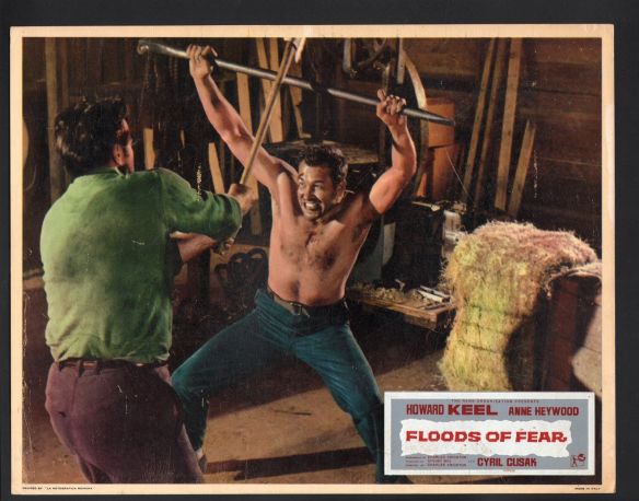 Howard Keel as an escaped prisoner (who was falsely incarcerated) defends himself in Floods of Fear (1958).